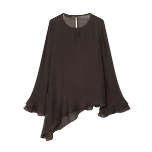 Détail de la blouse marron avec un ourlet asymétrique et des poignets à volants
