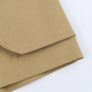 Vue macro montrant les coutures doubles et la texture en sergé kaki de la jupe