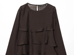 Détail du haut à manches longues marron foncé avec volants superposés et col rond chic