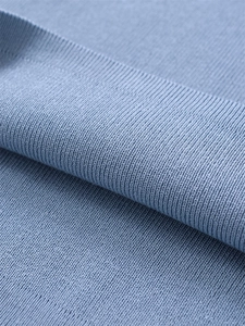 Macro shot of sky blue knitted fabric texture showing premium soft cotton fibers