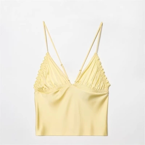 Light yellow silk satin camisole featuring a V-neckline and ruffled lace trim details