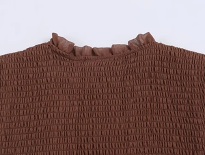 Detail of smocking texture and ruffle collar on a French vintage slim brown long sleeve top