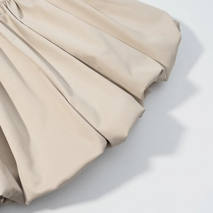 Detailopname van kaki getextureerde stof met elegante geplooide vouwen en matte finish