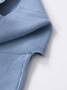 Close-up of the light blue knit fabric showing texture and seam craftsmanship on the neck