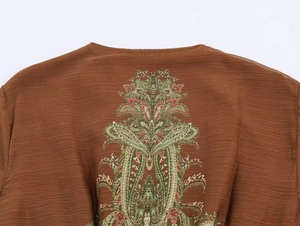 Detail of bohemian paisley floral print on caramel brown pleated fabric neckline