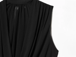 Detail of black V-neck sleeveless top with pleated texture and vertical chiffon fabric