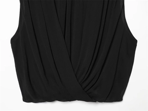 Close-up of black pleated wrap top featuring a V-neckline and fine chiffon texture