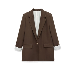 Detail eines dunkelbraunen Oversize-Blazers mit gestreiftem Futter an den Ärmeln
