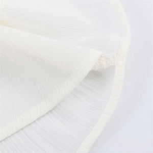 Detailed macro view of white pleated chiffon fabric with vertical stripes and fine stitching