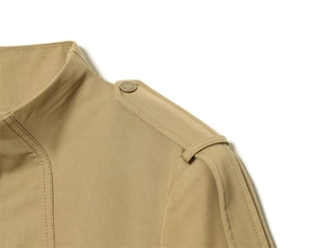 Detail of khaki jacket shoulder with epaulette and bronze metal button design