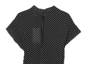Detail of black polka dot dress featuring a back zipper and high neck button closure