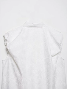 Macro shot of white textured seersucker fabric and standing collar detail on the back