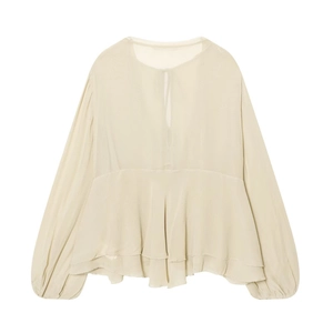 Detail of beige layered ruffle hem and balloon sleeves on a lightweight V-neck blouse