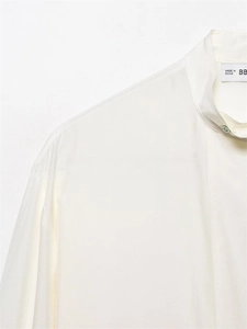 Detail of elegant stand collar and pearl button on ivory silk satin blouse