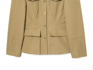 Detail of khaki jacket showing snap button closure and flap pockets with structured stitching