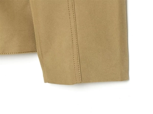 Detailed close-up of khaki twill fabric with professional double stitching on the hem