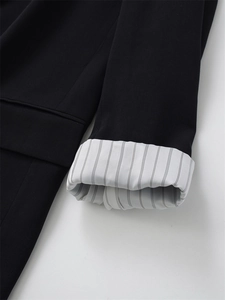 Detail der Ärmelmanschette mit schwarzem Stoff und gestreiftem weißem Innenfutter