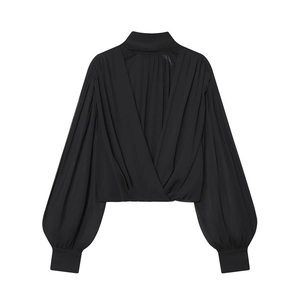 Detail of black wrap-style top with high neck, pleated lantern sleeves, and wide cuffs