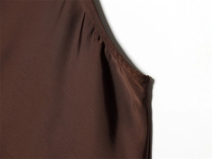 Gros plan détaillé du haut en satin marron foncé montrant la texture lisse et les coutures