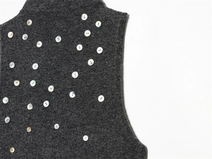 Détail du tissu en laine gris foncé avec plusieurs boutons blancs nacrés décoratifs