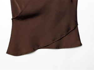 Détail du tissu satiné marron foncé avec drapé élégant et design portefeuille