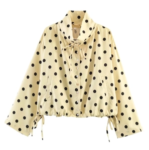 Detailed view of yellow polka dot jacket showing drawstring collar and button front