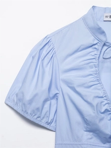 Dettaglio camicia in popeline azzurra con maniche a sbuffo e scollo con coulisse