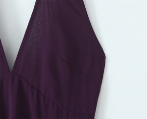 Detail shot of plum purple halter neck dress showing V-neck design and fabric texture