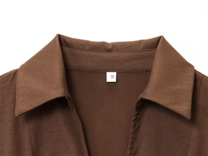 Détail du col en V et de l'étiquette taille S sur une robe marron foncé ajustée