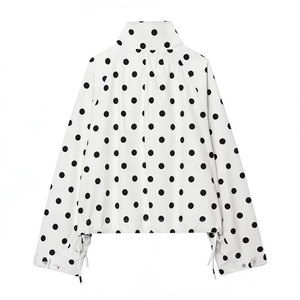 Detail view of the back of a white polka dot jacket with drawstring cuffs and a stand collar
