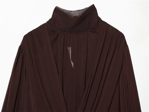Detailed macro view of deep brown pleated chiffon fabric texture on a high neck blouse