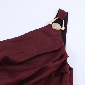 Détail d'une robe bordeaux en mélange de lin avec boucle dorée et décor en marbre