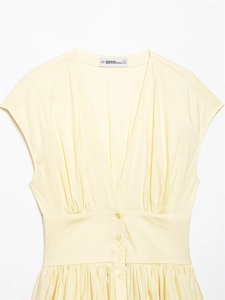 Détail de la robe en popeline jaune clair avec taille froncée et petits boutons centraux