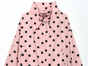 Detail of light pink polka dot shirt featuring a funnel neck with adjustable drawstrings