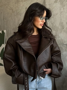Detail shot of a dark brown faux leather moto jacket featuring a belt and lapel