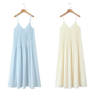 Detail of V-neck pleated mini dress showing light blue and off-white fabric texture
