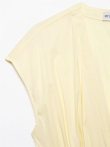 Détail de robe en popeline jaune clair avec décolleté en V et texture d'épaule plissée