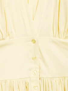 Détail de la mini robe en popeline jaune clair avec taille plissée et boutons