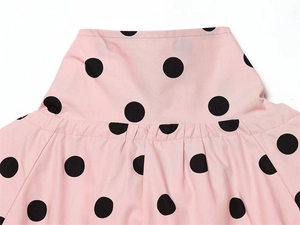 Detail of pink polka dot blouse neck structure with smooth fabric texture