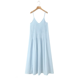 Detail of light blue V-neck dress featuring elegant vertical pleats and airy fabric texture