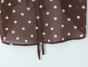 Vue détaillée du tissu en mousseline marron foncé avec pois blancs et cordon de serrage