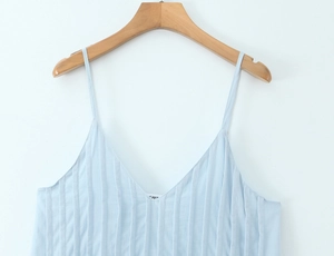 Close-up of light blue pleated camisole top with thin straps and V-neckline detail