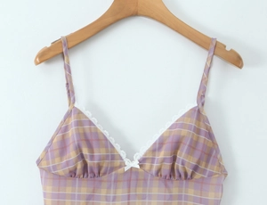 Vista dettagliata del top a quadri viola con bordo in pizzo bianco e fiocco decorativo