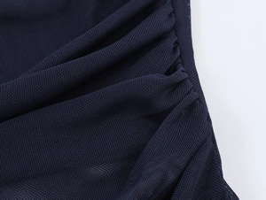 Close-up of navy blue ruched mesh fabric texture with fine breathable grid pattern