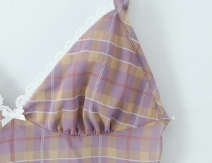 Dettaglio macro del tessuto a quadri viola con pizzo bianco e fiocco decorativo