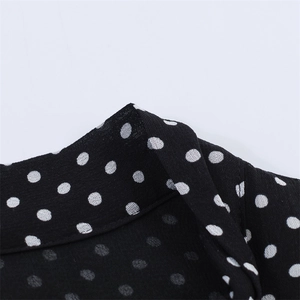 Close-up of black and white polka dot dress fabric with breathable chiffon texture