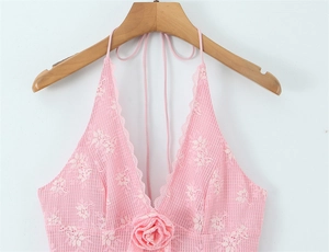 Dettaglio del top a fionda in pizzo rosa con rosa 3D applicata e trama a rete