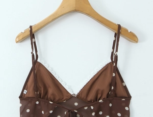 Détail du haut court à pois marron avec dentelle blanche et étiquette taille S sur cintre