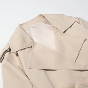 Detail of beige jacket showing wide lapels, shoulder epaulets and smooth inner lining
