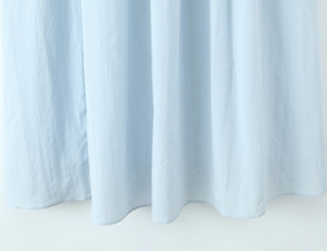 Detailed view of the pleated light blue dress hem with fine rolled edge stitching
